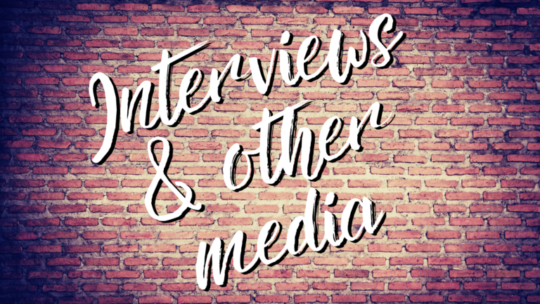 A brick wall with faded edges and the words Interviews & other media in the center in a messy cursive font.